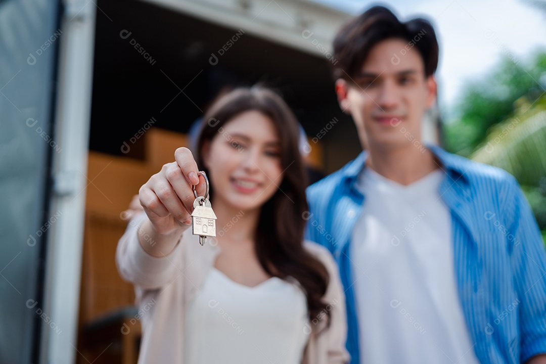 Verificação de casal asiático ao descarregar caixas e móveis de uma caminhonete para uma nova casa