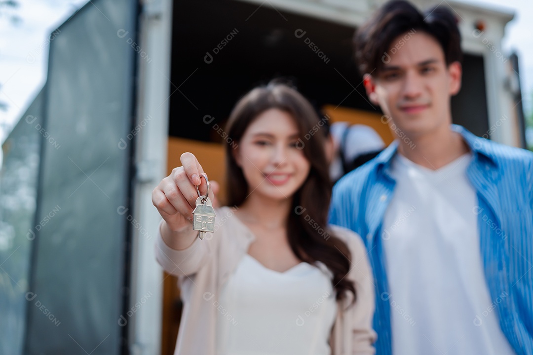 Verificação de casal asiático ao descarregar caixas e móveis de uma caminhonete para uma nova casa