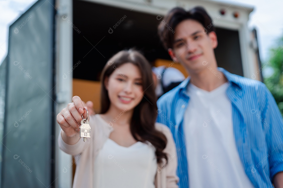 Verificação de casal asiático ao descarregar caixas e móveis de uma caminhonete para uma nova casa