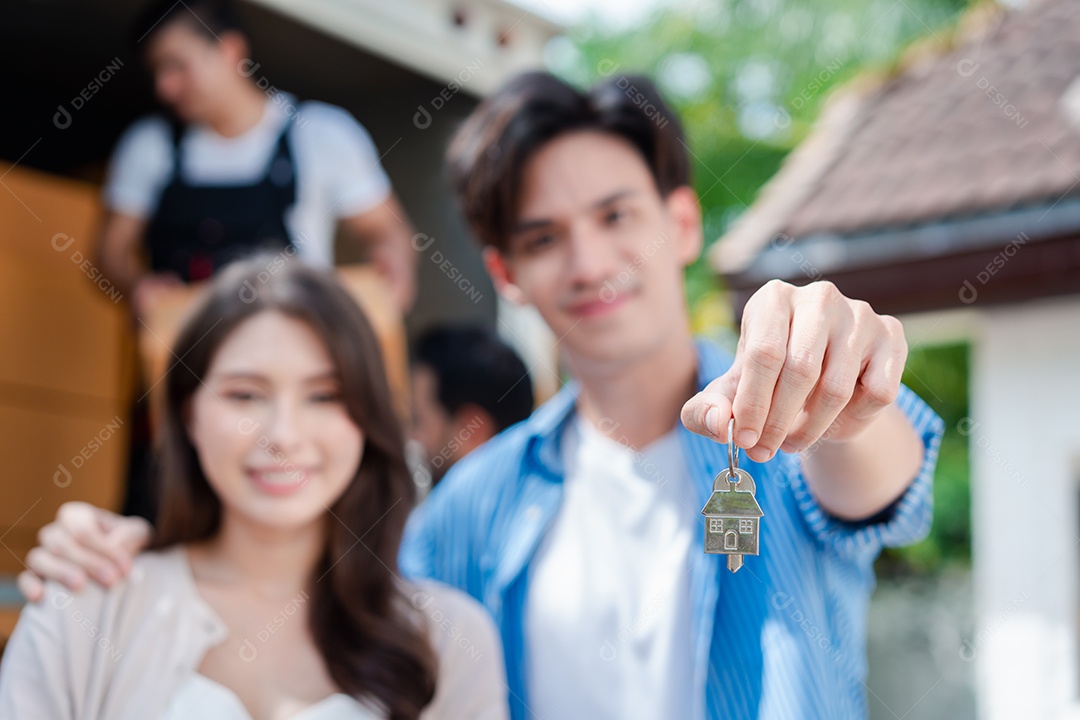 Verificação de casal asiático ao descarregar caixas e móveis de uma caminhonete para uma nova casa