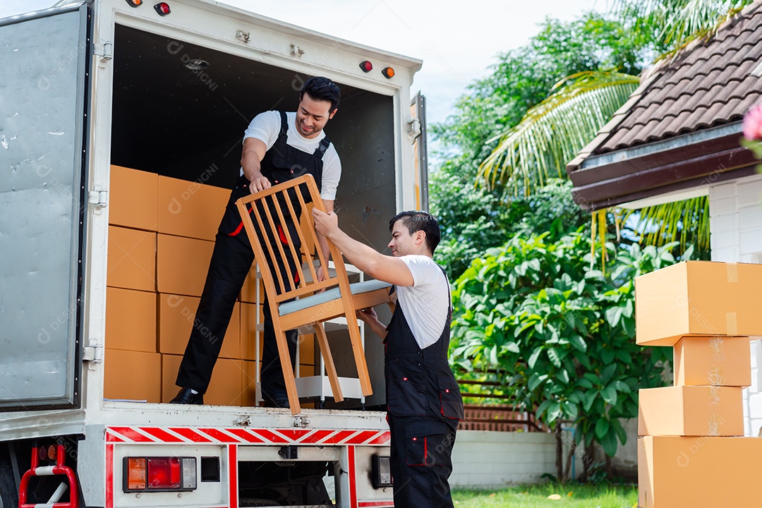 Verificação de casal asiático ao descarregar caixas e móveis de uma caminhonete para uma nova casa