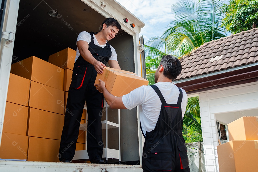 Verificação de casal asiático ao descarregar caixas e móveis de uma caminhonete para uma nova casa