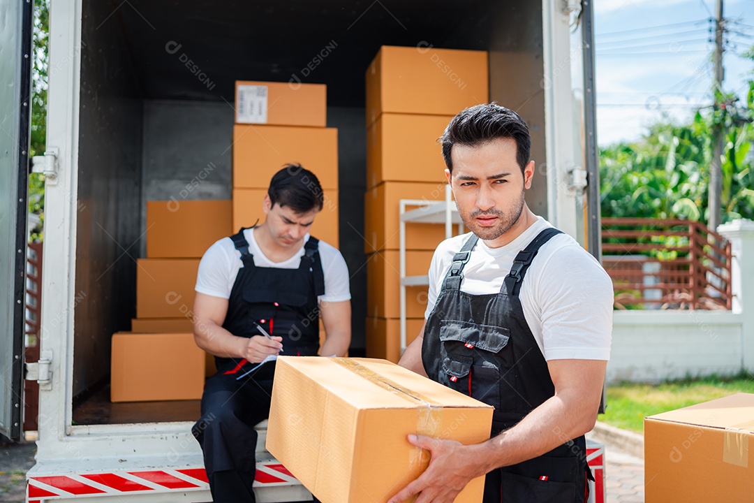 Verificação de casal asiático ao descarregar caixas e móveis de uma caminhonete para uma nova casa