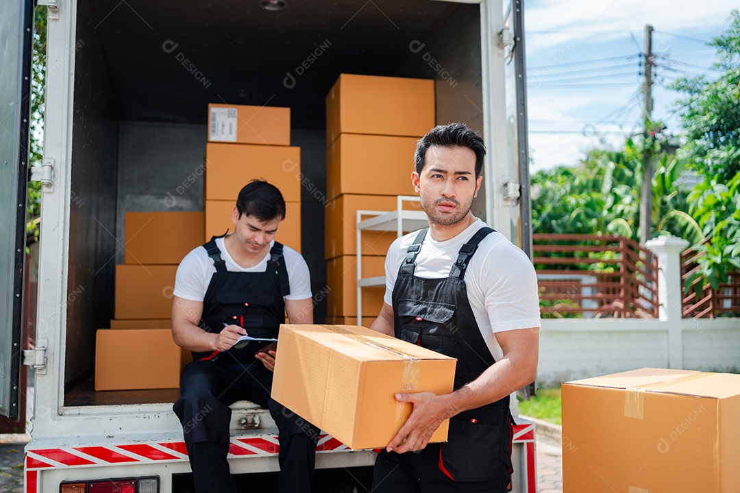 Verificação de casal asiático ao descarregar caixas e móveis de uma caminhonete para uma nova casa