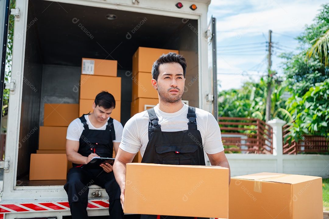 Verificação de casal asiático ao descarregar caixas e móveis de uma caminhonete para uma nova casa