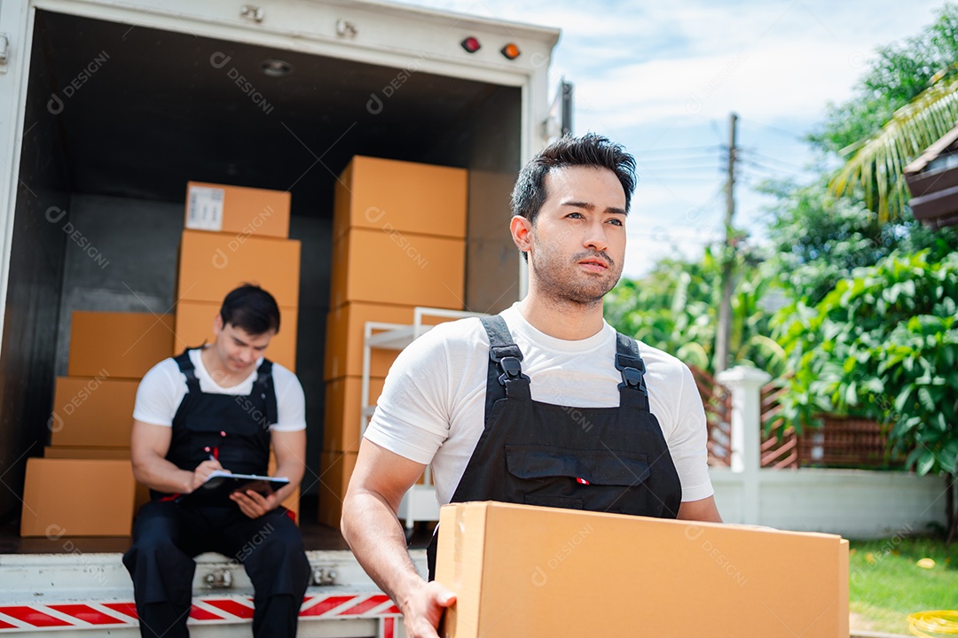Verificação de casal asiático ao descarregar caixas e móveis de uma caminhonete para uma nova casa