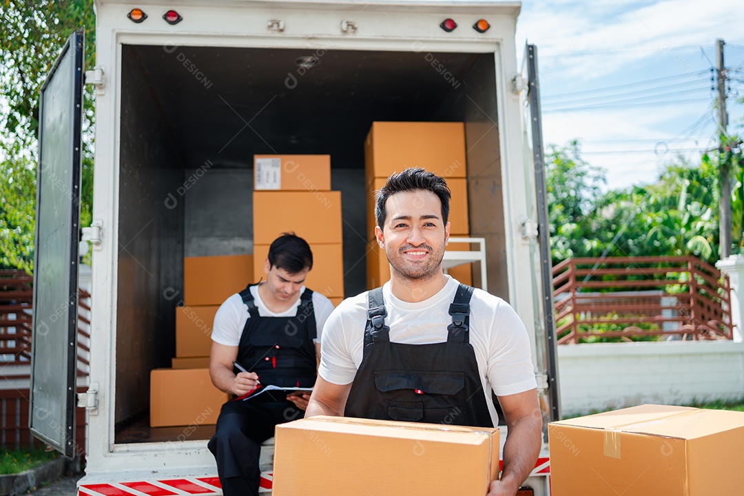 Verificação de casal asiático ao descarregar caixas e móveis de uma caminhonete para uma nova casa