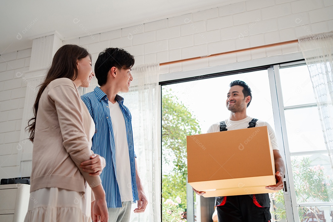 Verificação de casal asiático ao descarregar caixas e móveis de uma caminhonete para uma nova casa