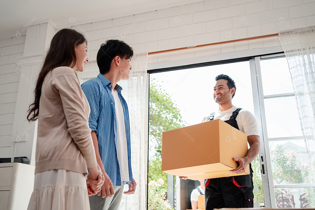 Verificação de casal asiático ao descarregar caixas e móveis de uma caminhonete para uma nova casa