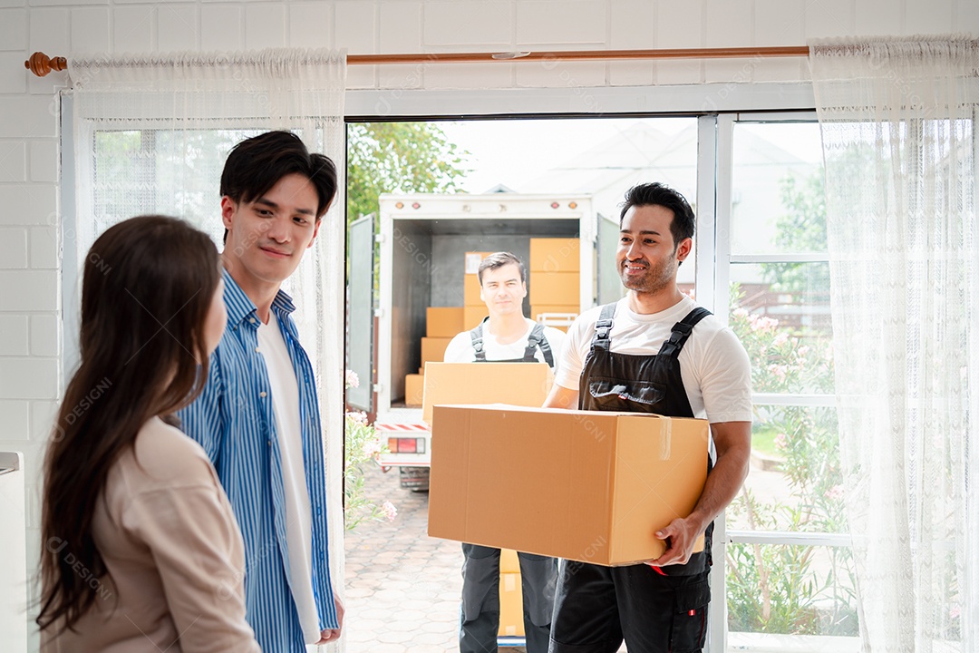 Verificação de casal asiático ao descarregar caixas e móveis de uma caminhonete para uma nova casa