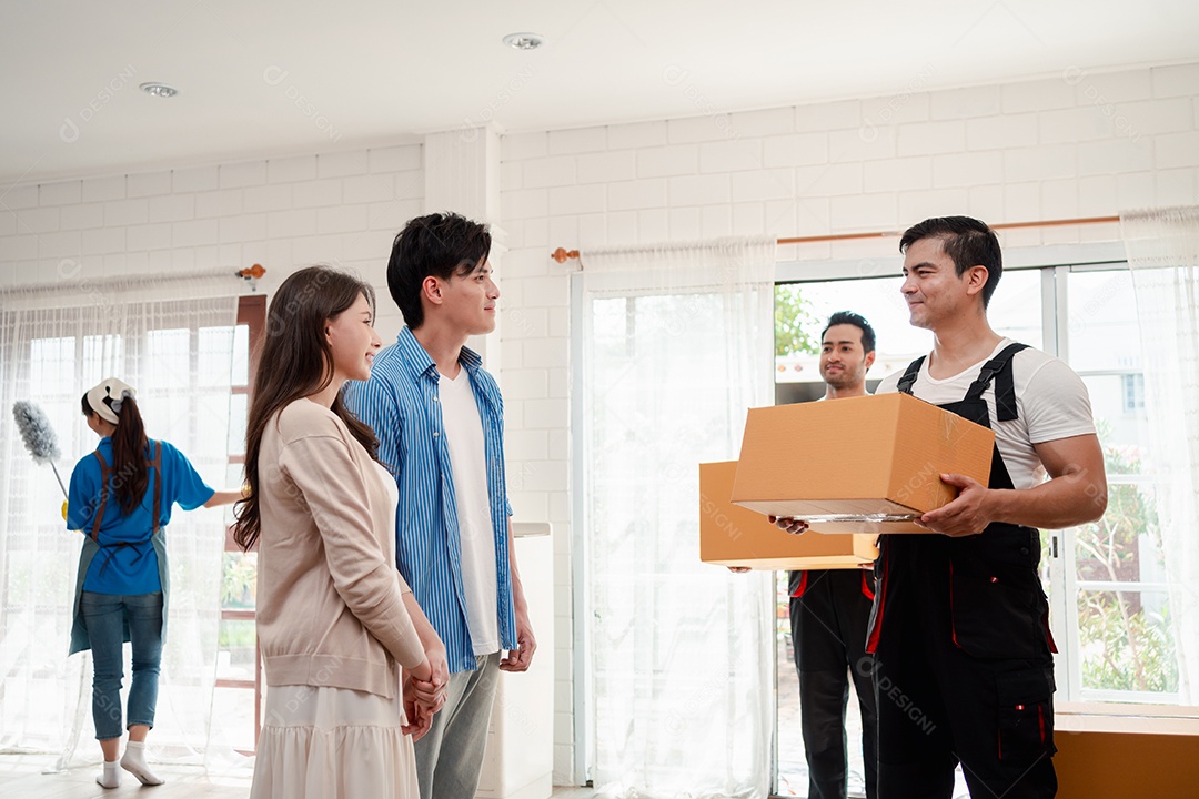 Verificação de casal asiático ao descarregar caixas e móveis de uma caminhonete para uma nova casa