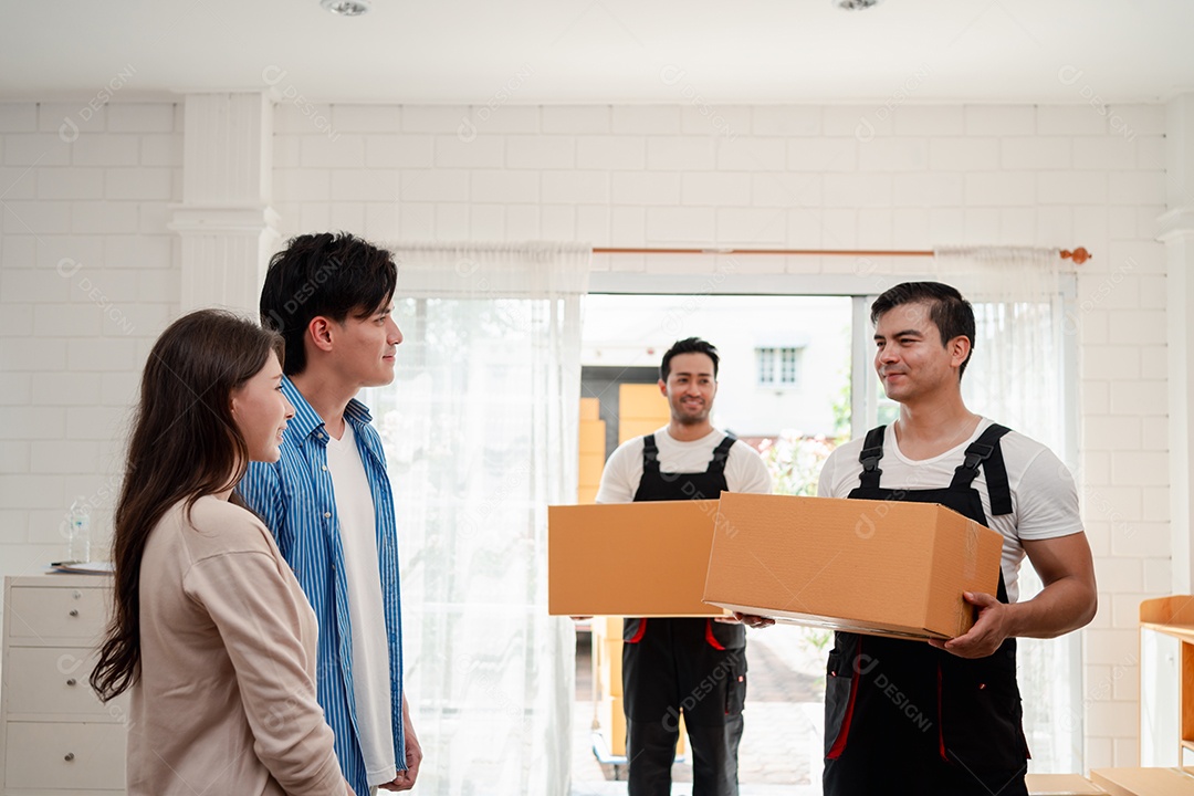 Verificação de casal asiático ao descarregar caixas e móveis de uma caminhonete para uma nova casa