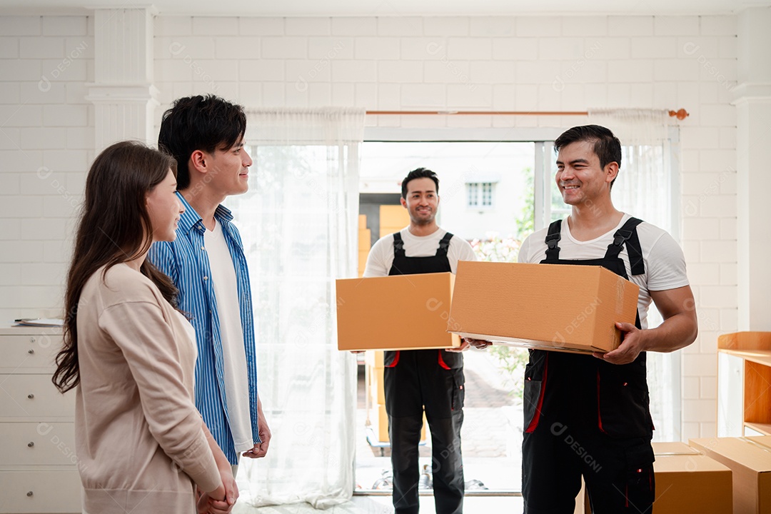 Verificação de casal asiático ao descarregar caixas e móveis de uma caminhonete para uma nova casa