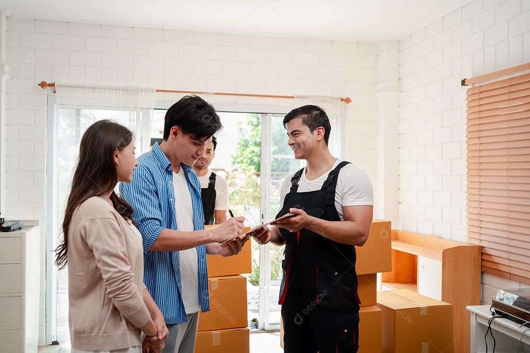 Verificação de casal asiático ao descarregar caixas e móveis de uma caminhonete para uma nova casa