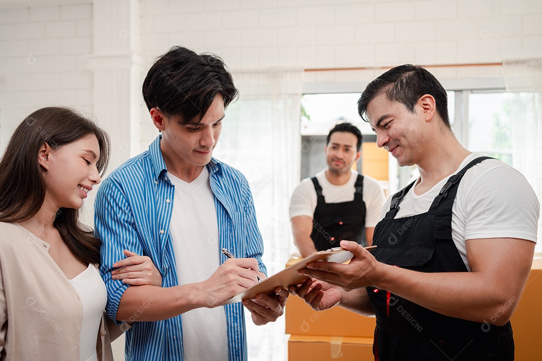 Verificação de casal asiático ao descarregar caixas e móveis de uma caminhonete para uma nova casa