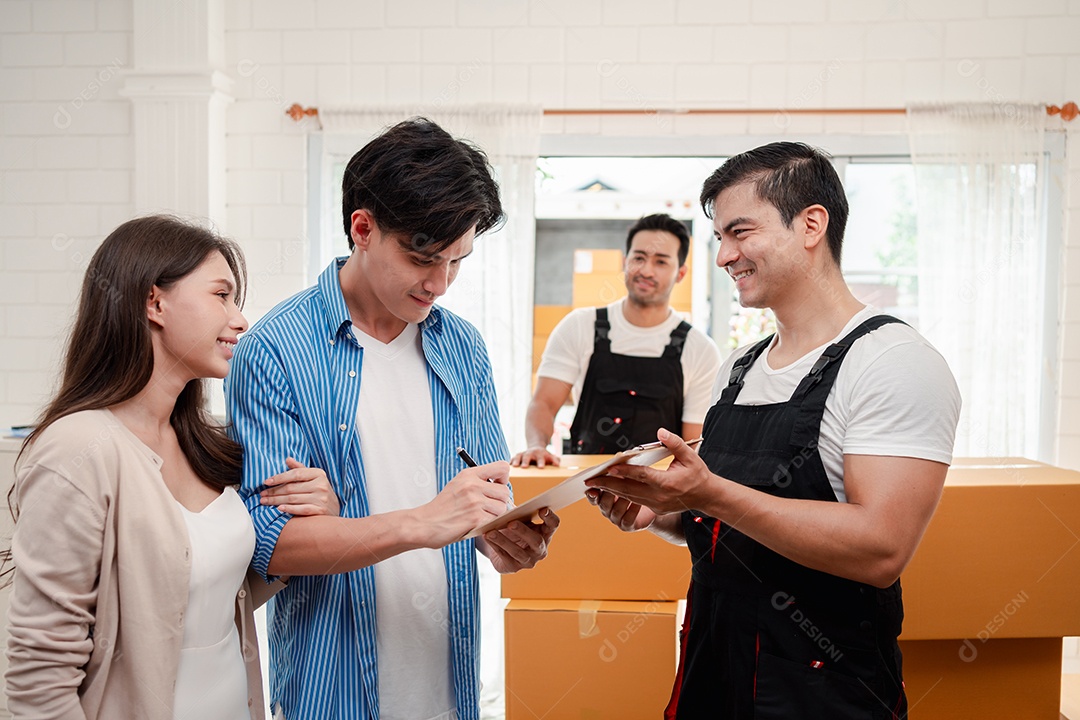 Verificação de casal asiático ao descarregar caixas e móveis de uma caminhonete para uma nova casa