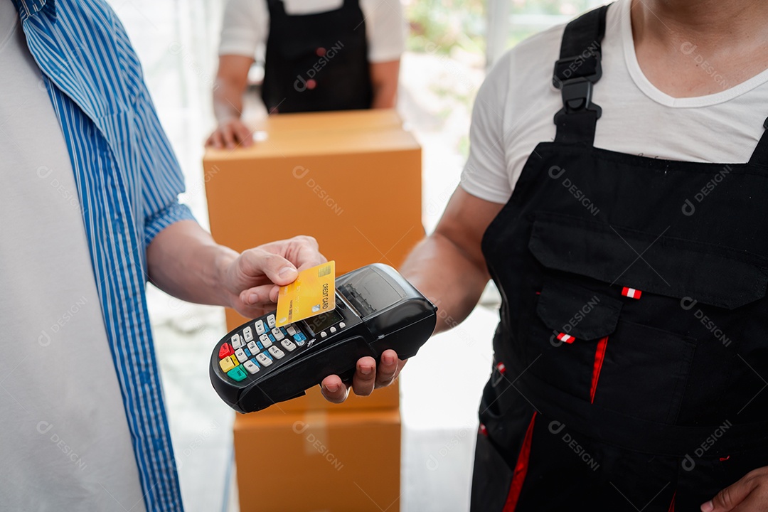 Verificação de casal asiático ao descarregar caixas e móveis de uma caminhonete para uma nova casa