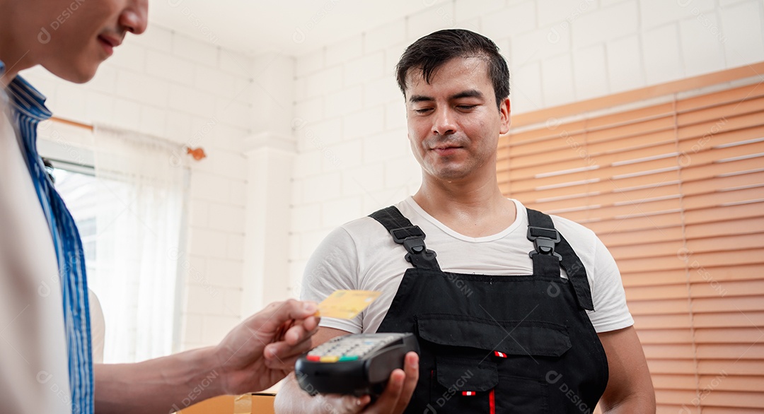 Verificação de casal asiático ao descarregar caixas e móveis de uma caminhonete para uma nova casa