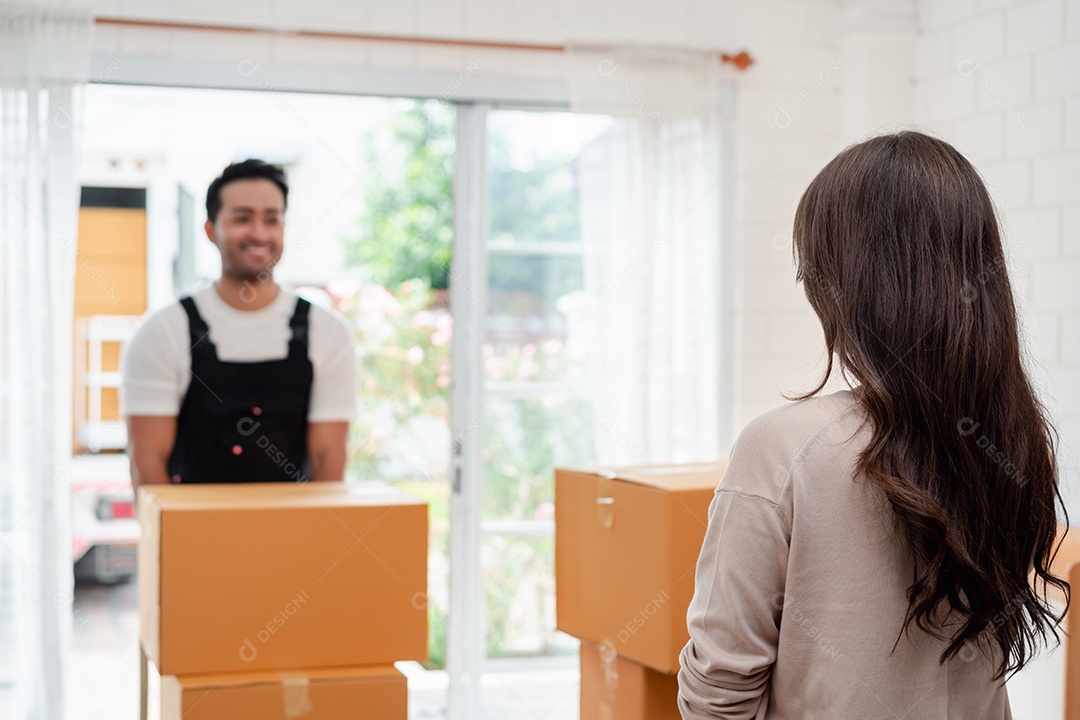 Verificação de mulher ao descarregar caixas e móveis de uma caminhonete para uma nova casa