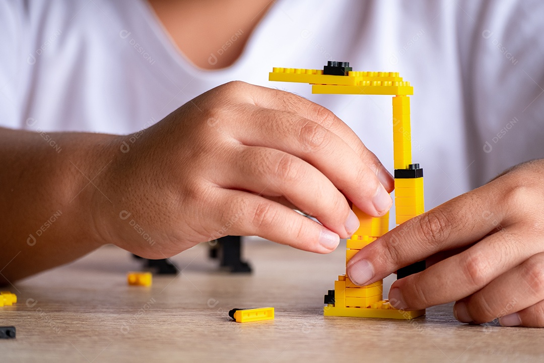menina asiática de 5 a 6 anos brincando com tijolos Lego ou brinquedo em casa