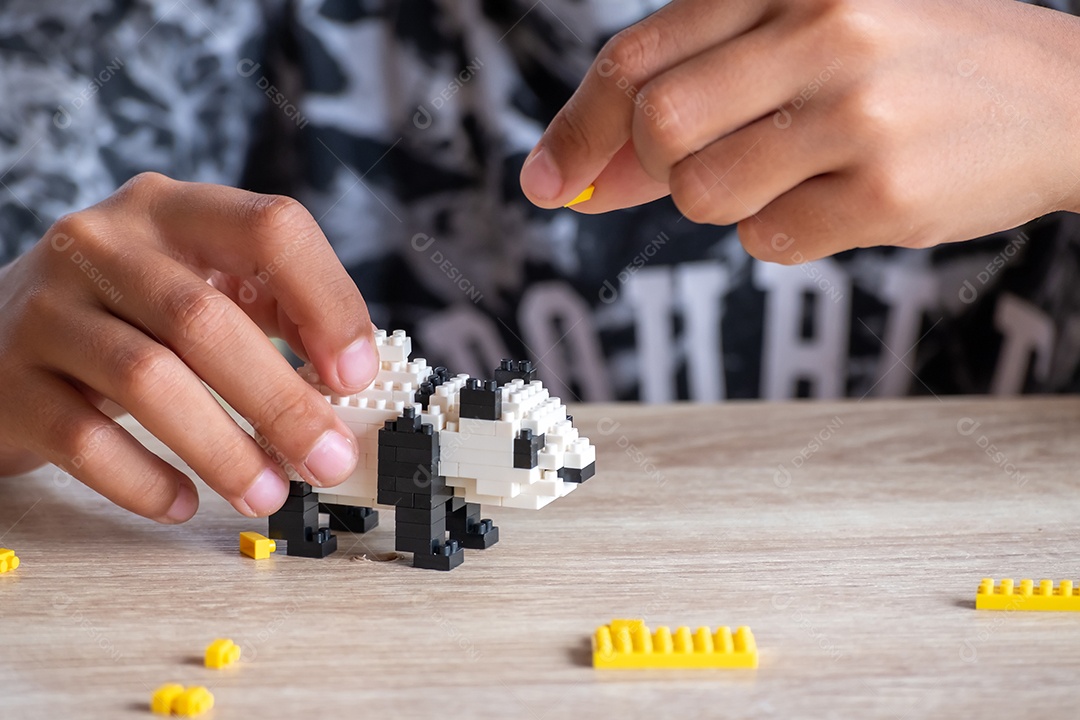 menina asiática de 5 a 6 anos brincando com tijolos Lego ou brinquedo em casa