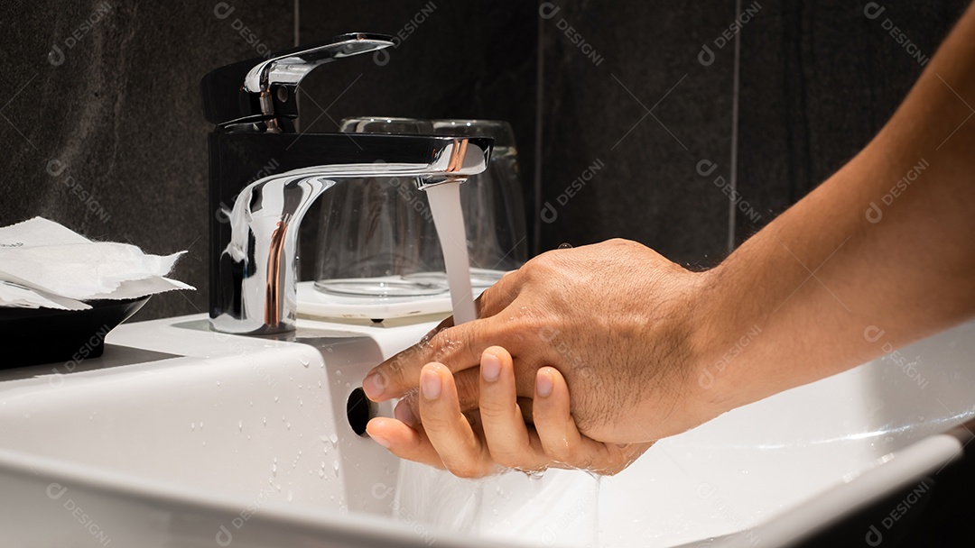 A mão do homem está derramando na pia de um dos luxuosos banheiros da propriedade.