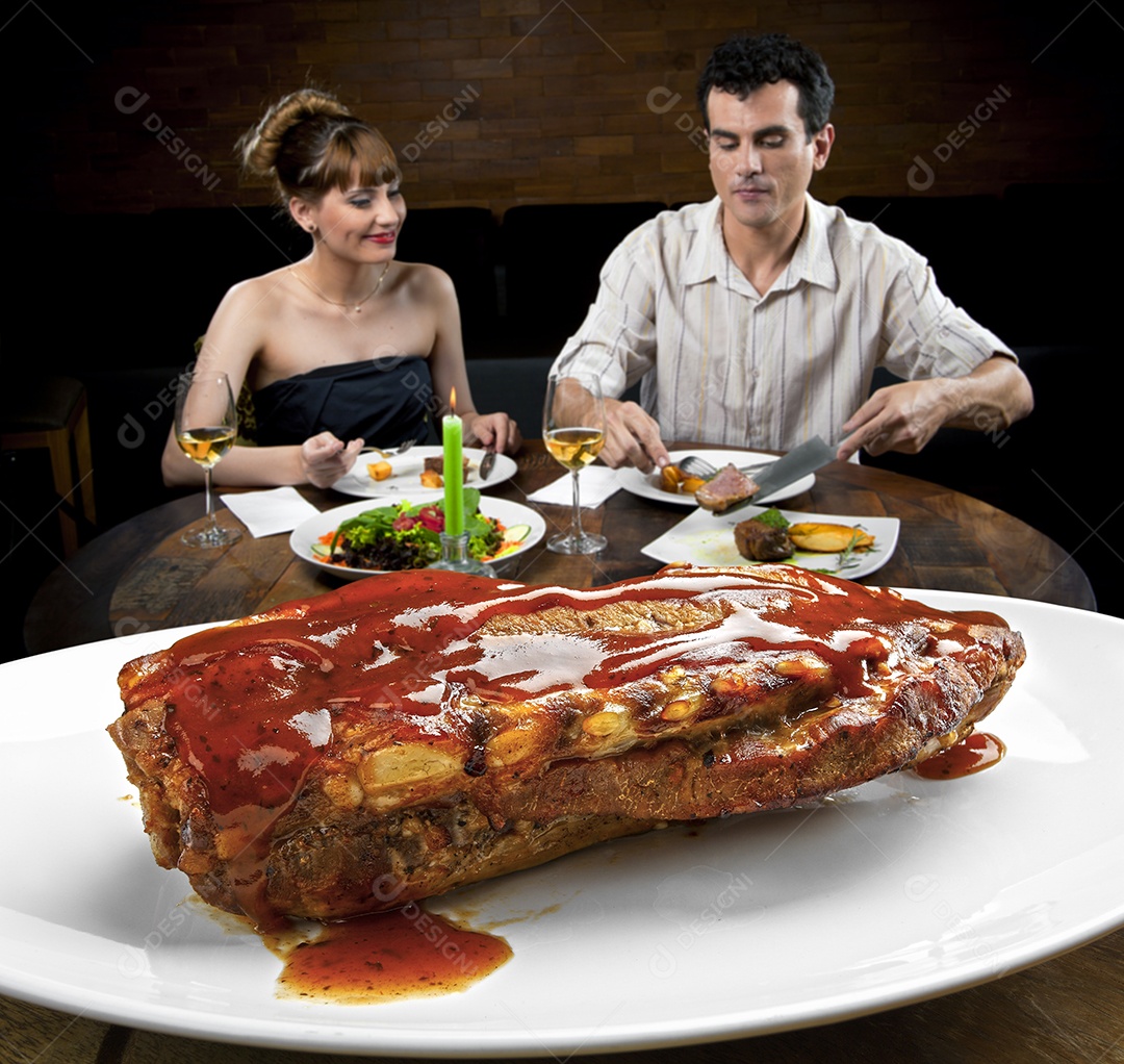 Costela assada com molho sobre prato branco