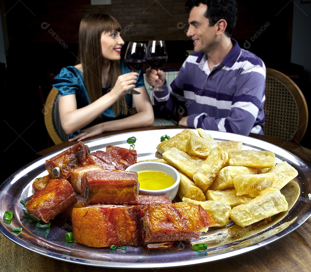 Porção de carne frita com mandiocas e molho