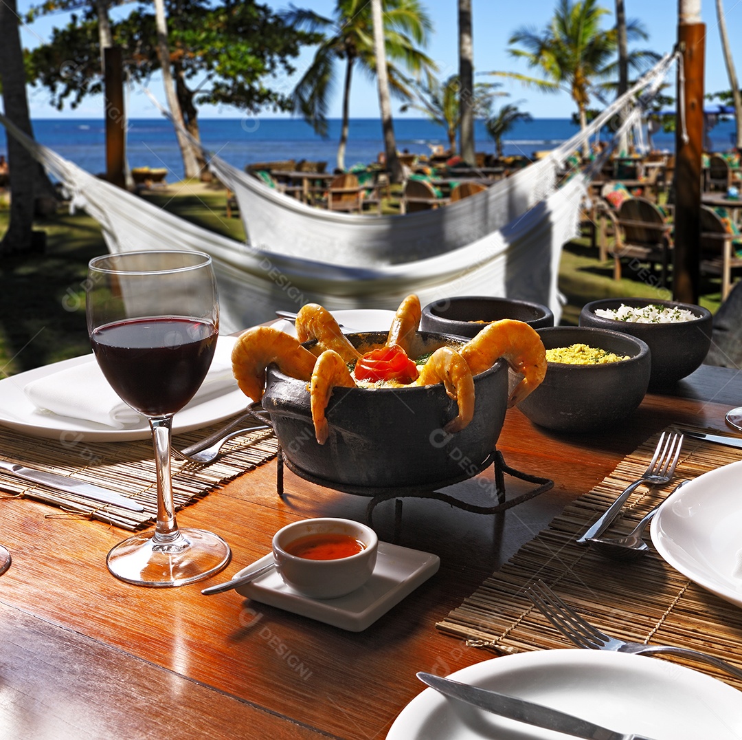 Moqueca de camarão com taça de vinho