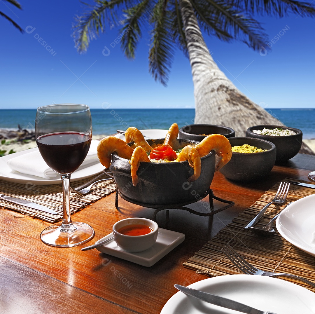 Moqueca de camarão ao creme amarelo e taças de vinho