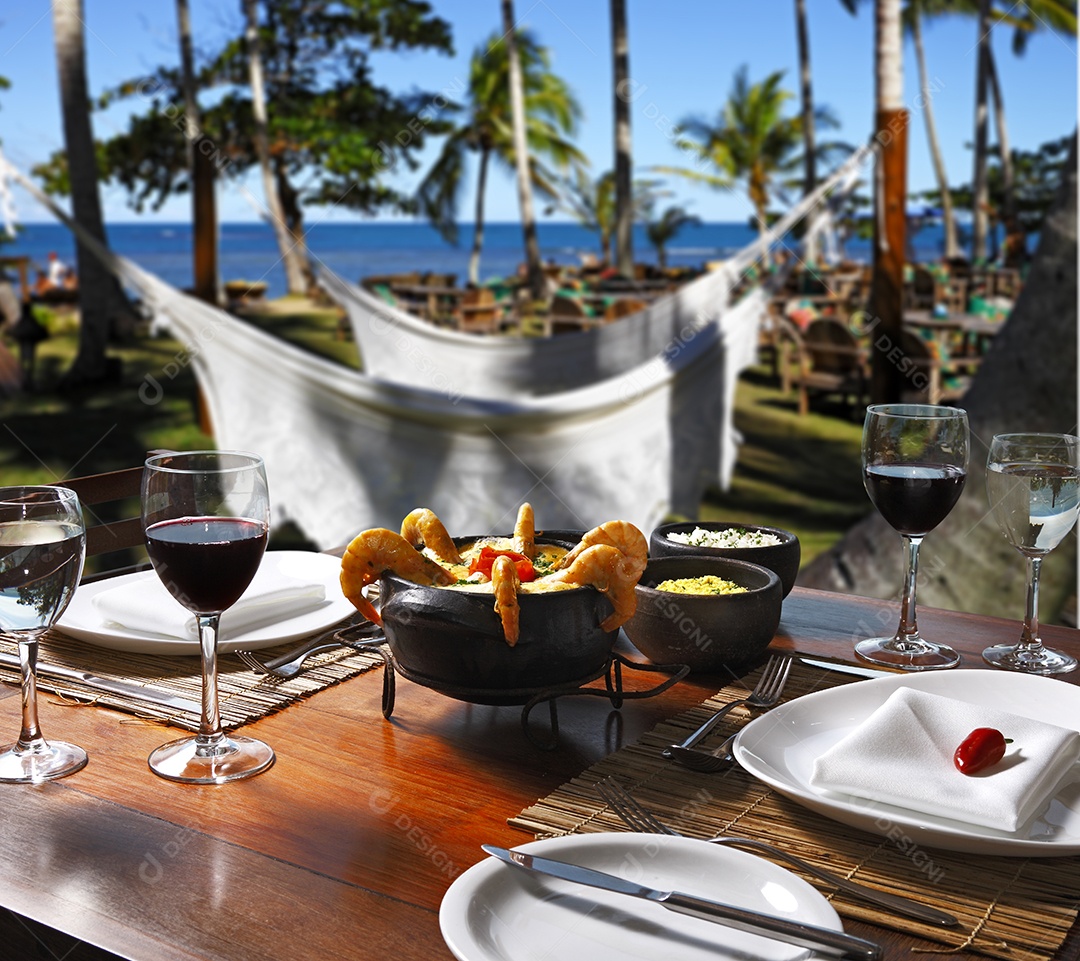 Moqueca de camarão ao creme e taça e vinho