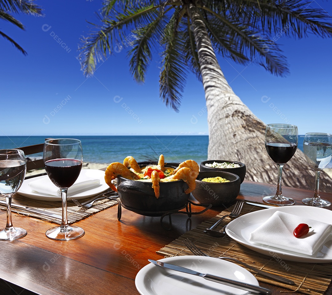 Moqueca de camarão ao creme amarelo e taças de vinho