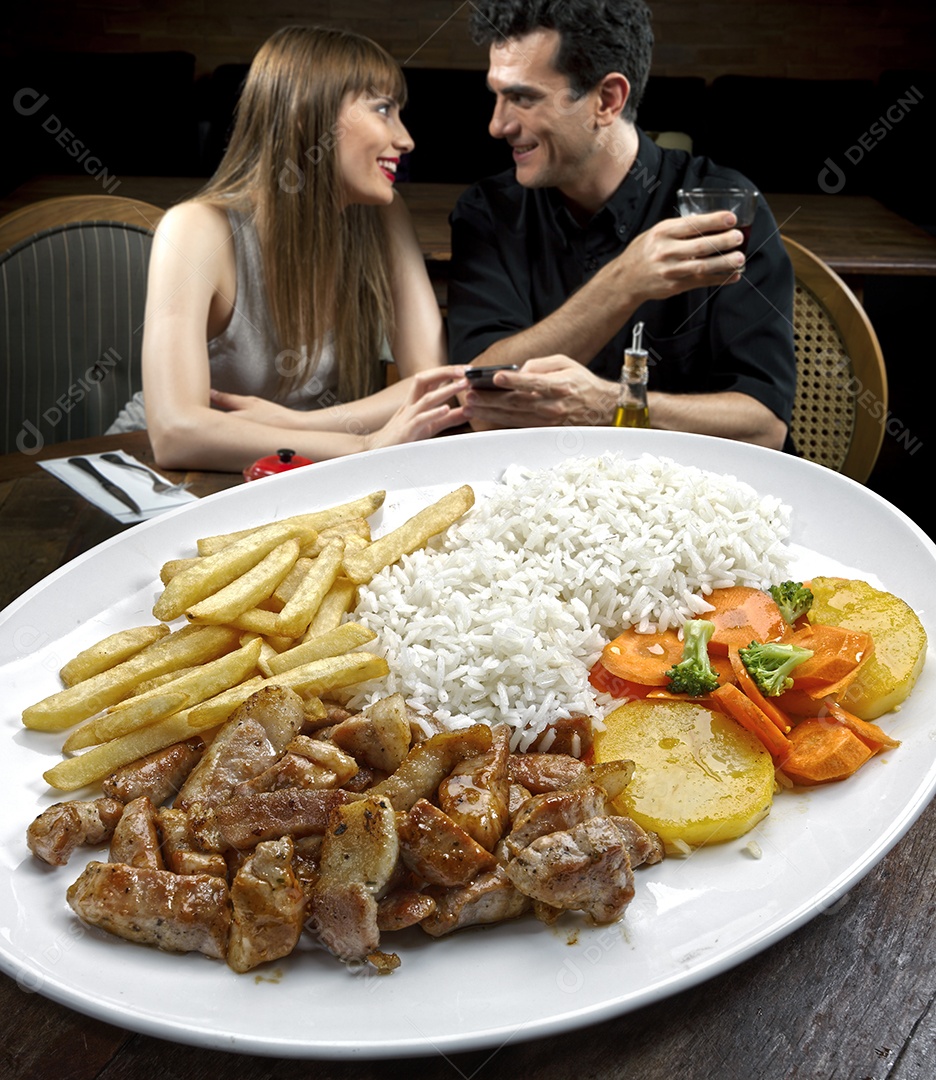 Comida tradicional com batatas arroz salada e carne