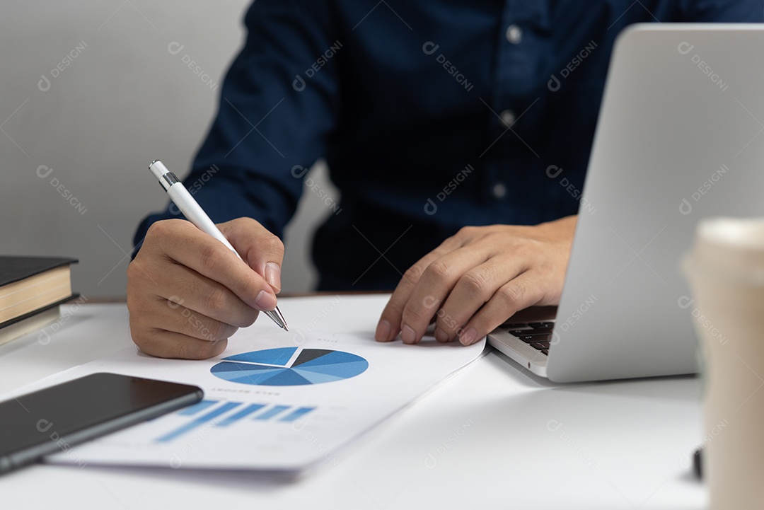 Empresário segurando gráfico de documento de caneta e gráfico segurando marketing de contabilidade de caneta com computador portátil.