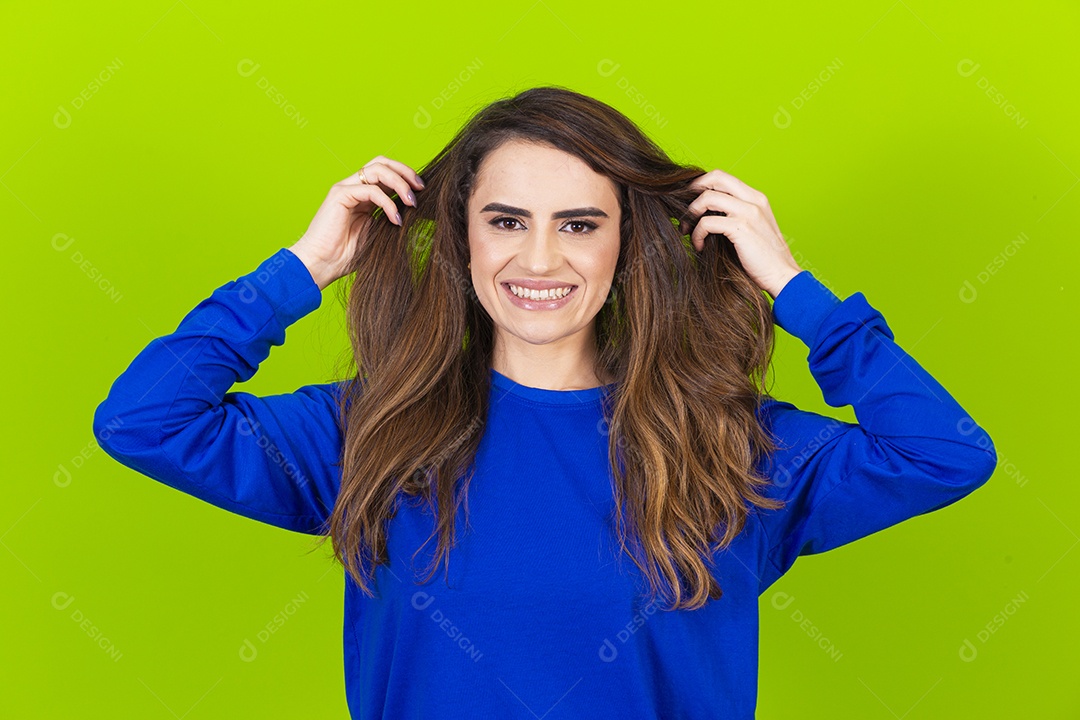 Linda mulher sorridente com blusa azul em fundo verde