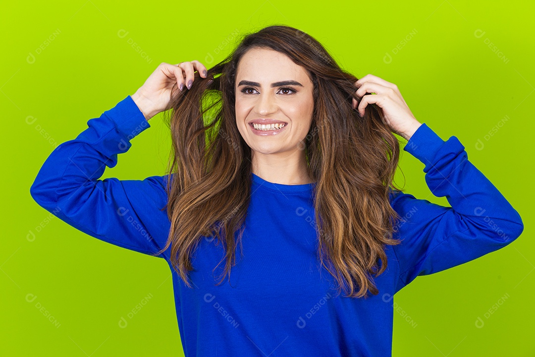 Linda mulher sorridente com blusa azul em fundo verde