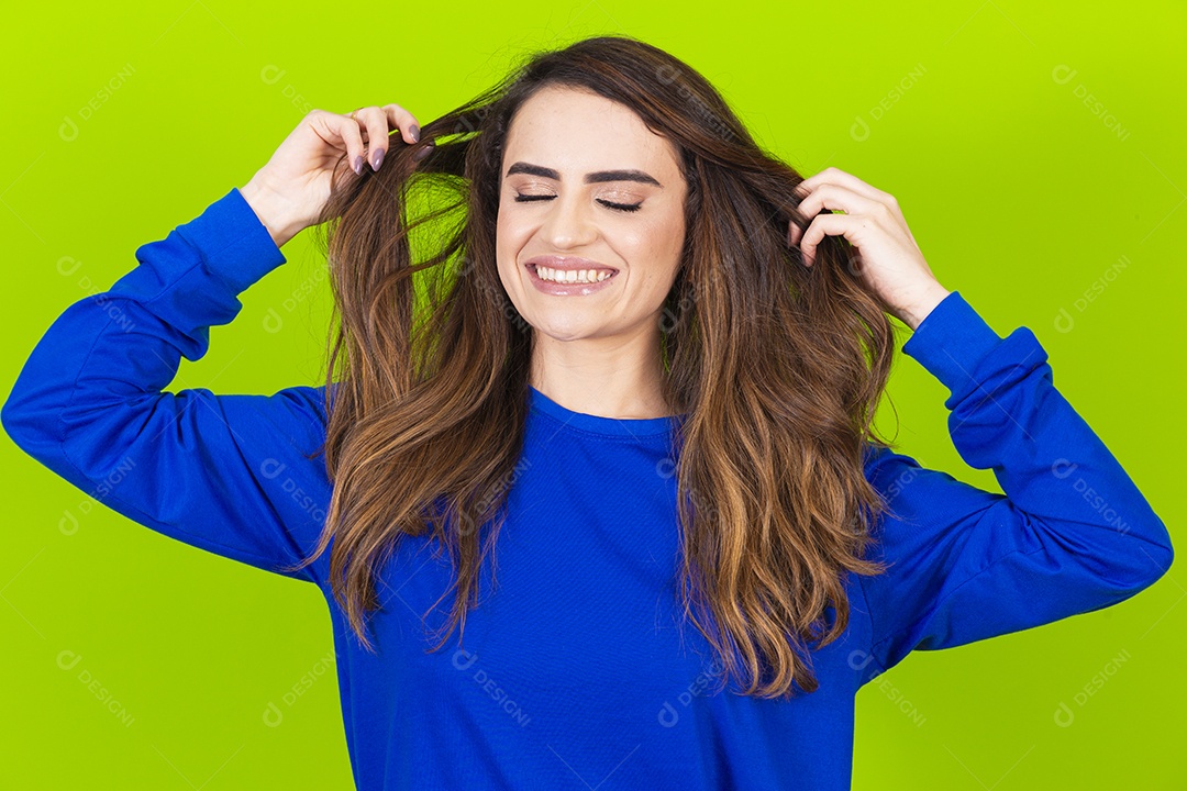 Linda mulher sorridente com blusa azul em fundo verde