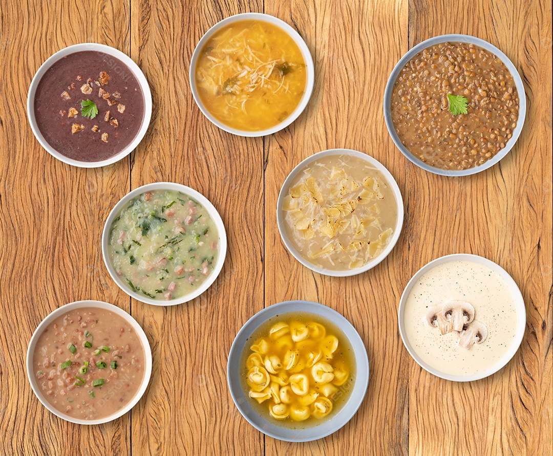 Vários sabores de sopa em tigelas sobre a mesa de madeira.