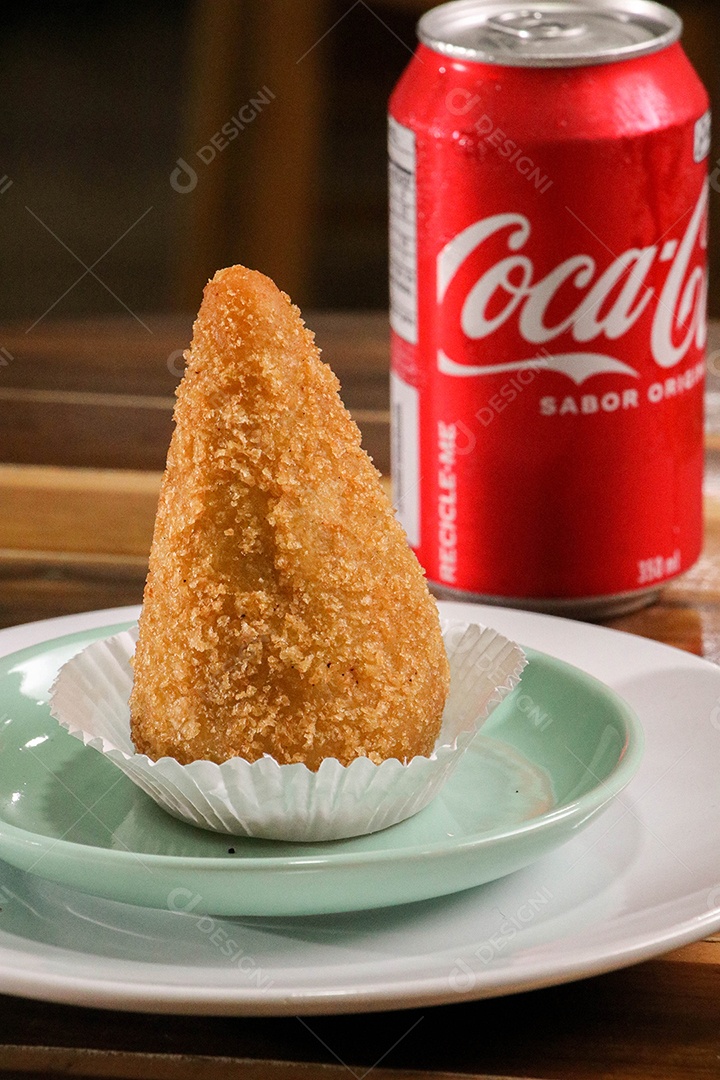 Deliciosa coxinha frita com lata de refrigerante