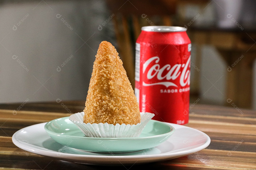 Deliciosa coxinha frita com lata de refrigerante