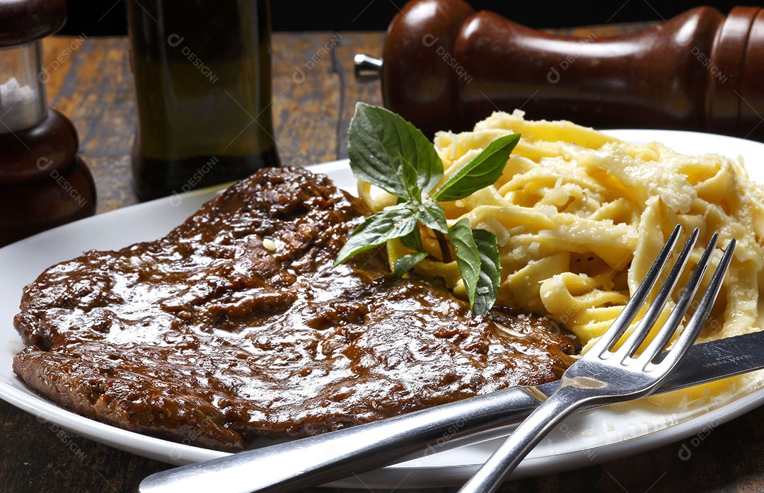 Refeição deliciosa bife grelhado e macarrão ao molho branco