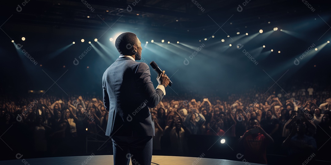 Palestrante se apresentando no palco com holofotes conversando com muitas pessoas na plateia
