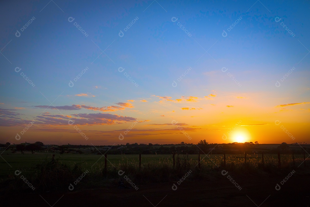 Dramático nascer do sol natural sobre o campo agrícola. Paisagem rural sob céu colorido cênico ao pôr do sol.
