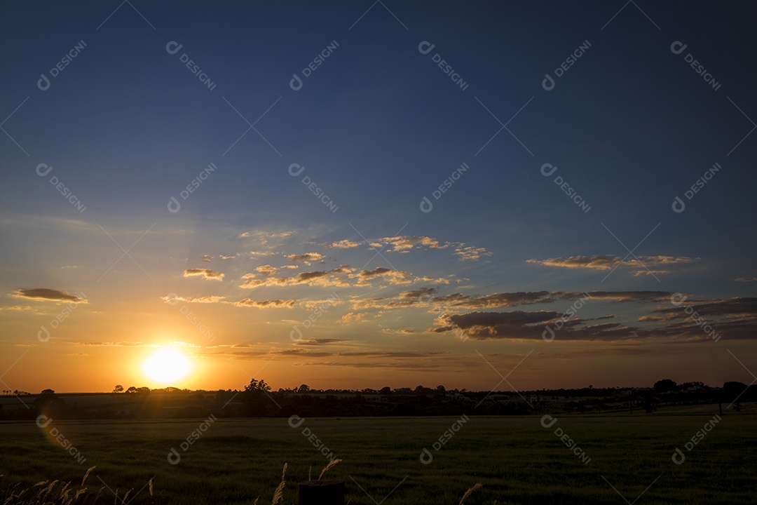 Dramático nascer do sol natural sobre o campo agrícola. Paisagem rural sob céu colorido cênico ao pôr do sol.