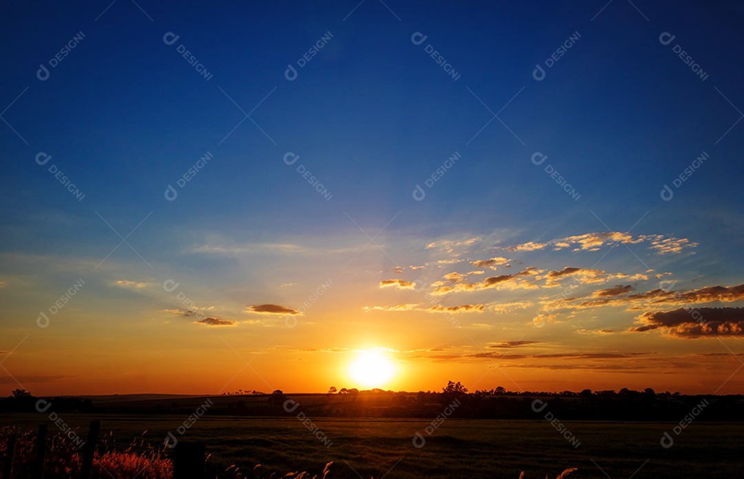 Dramático nascer do sol natural sobre o campo agrícola. Paisagem rural sob céu colorido cênico ao pôr do sol.