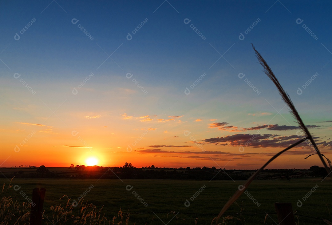 Dramático nascer do sol natural sobre o campo agrícola. Paisagem rural sob céu colorido cênico ao pôr do sol.