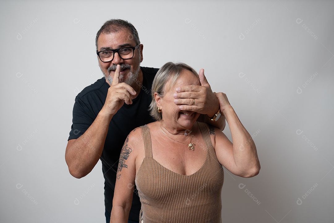 Casal emocional com cabelos grisalhos e barba contra fundo cinza.