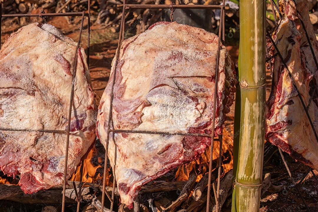 Carne pendurada assando ao ar livre