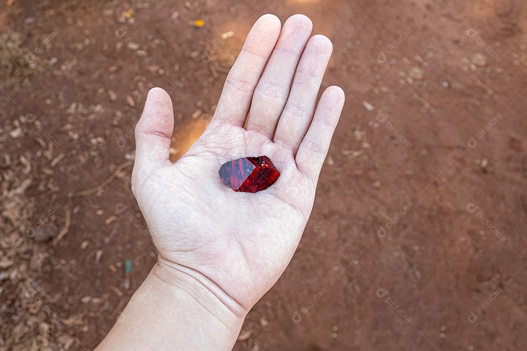 Mão branca limpa aberta com um pedaço de rubi