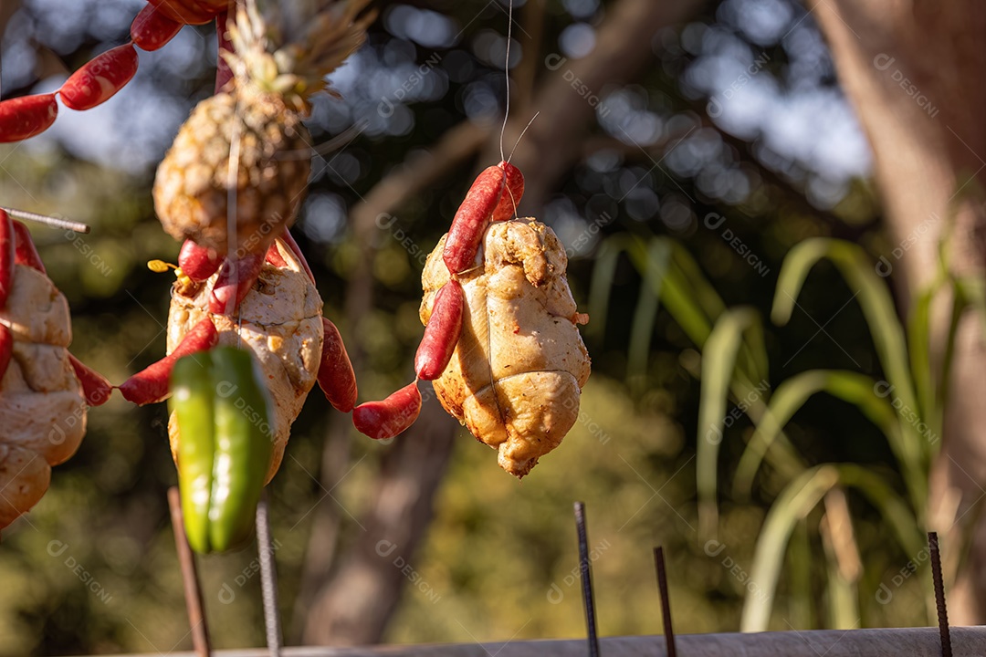 Carne de frango pendurada assando ao ar livre